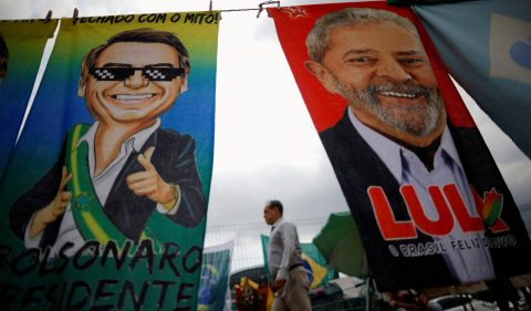 Eleições 2022: Pedestre passa por materiais de campanha presidencial que retratam o ex-presidente do Brasil Luiz Inácio Lula da Silva e o presidente Jair Bolsonaro. Foto: Reuters/Adriano Machado