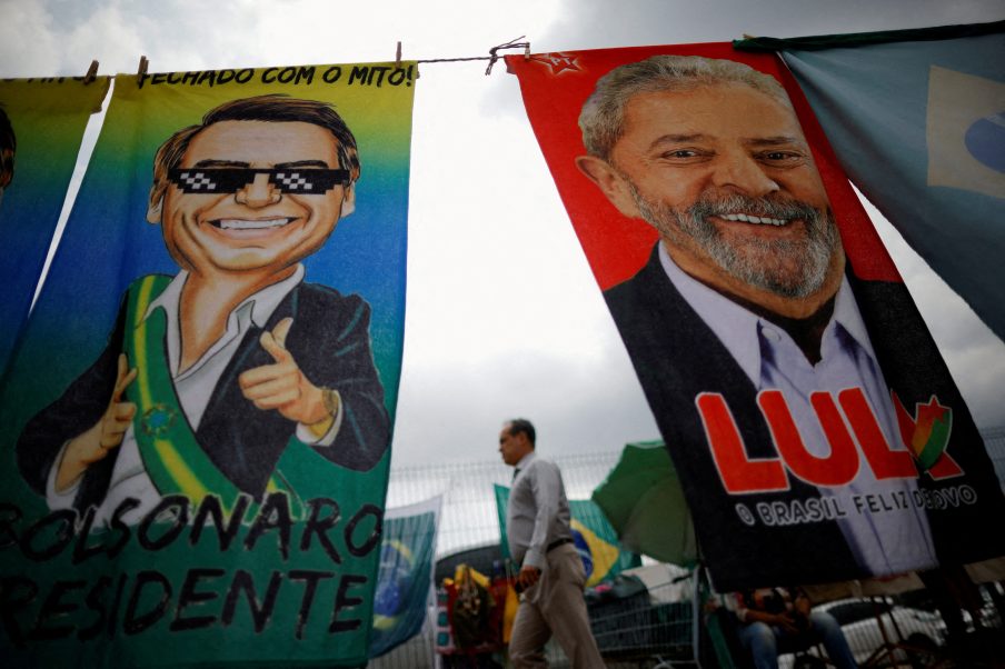Eleições 2022, Pedestre passa por materiais de campanha presidencial que retratam o ex-presidente do Brasil Luiz Inácio Lula da Silva e o presidente Jair Bolsonaro