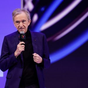 Bernard Arnault segurando um microfone em uma apresentação