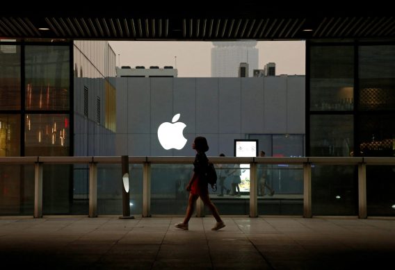 Imagem de uma pessoa caminhando em frente à loja da Apple.