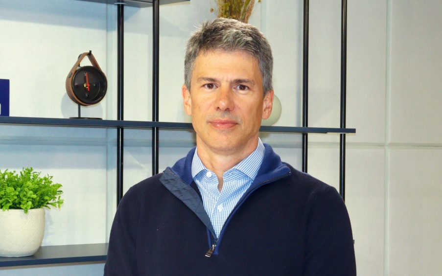 Foto do gestor Aymar Almeida. Ele é homem, branco e usa uma jaqueta azul. Aymar é gestor do fundo de debêntures de infraestrutura KDIF11.