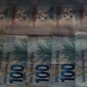 Imagens de notas de R$ 100 para ilustrar reportagem sobre os riscos da renda fixa