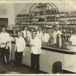 Imagem da década de 50 do restaurante Ponto Chic. Na foto, vários garçons no bar do restaurante.