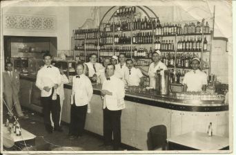 Imagem da década de 50 do restaurante Ponto Chic. Na foto, vários garçons no bar do restaurante.