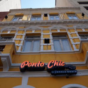 Imagem da fachada do restaurante Ponto Chic, localizado no Largo do Paissandu, em São Paulo. É um prédio antigo, de cores amarelas e brancas.