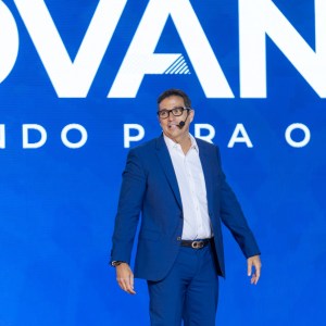 Foto de Roberto Campos Neto, economista e ex-presidente do banco Central. Ele é homem, usa terno azul e fala ao microfone sobre tarifas de Trump e risco de estaginflação no Brasil